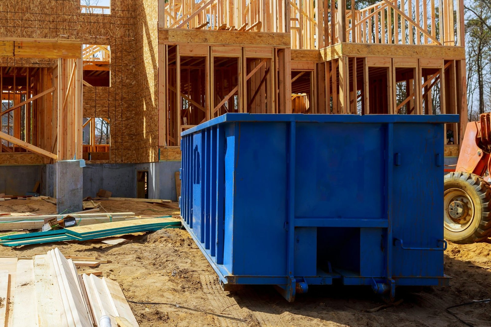 Old and used construction material in the new building frame of a new house under construction